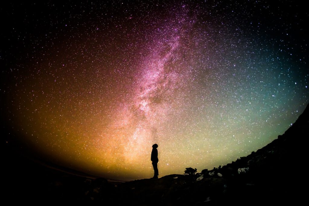 Photo: Night-time person looking up at Milky Way
